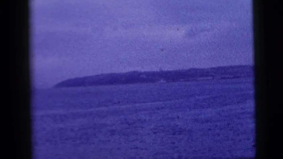 A blue-purple 8mm harbor view from 1958 shows open New York City water and a distant low shoreline near the end of the clip.
