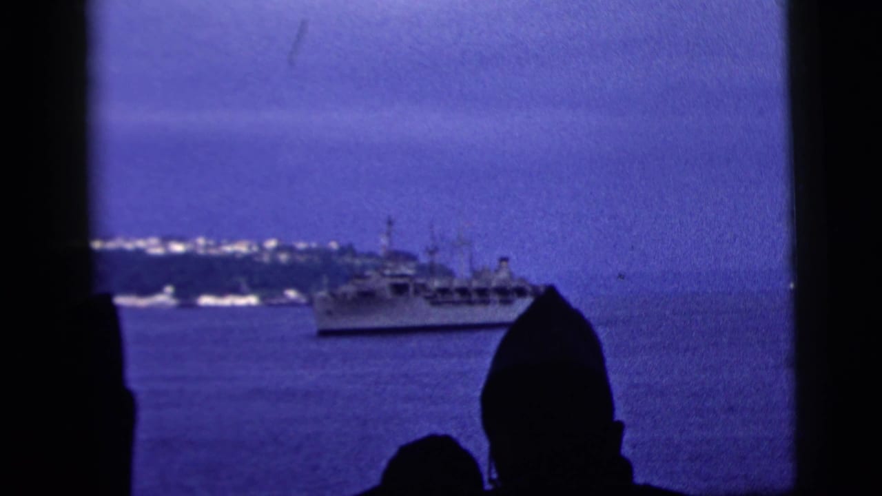 1958 New York City harbor footage showing a large vessel offshore with silhouetted viewers at the lower edge of the frame.