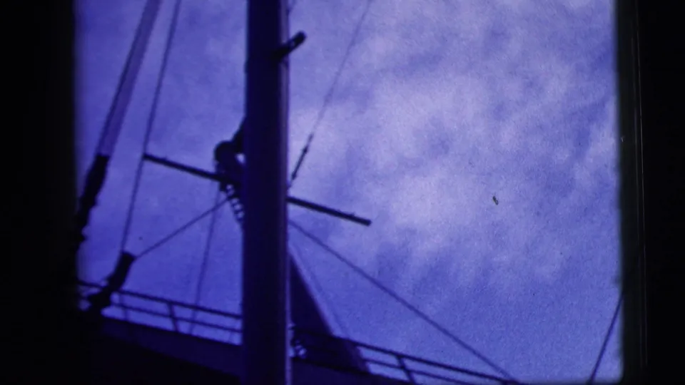 Final frame showing mast, crossbar, and rigging lines from the vessel, rendered in grainy blue 8mm exposure.