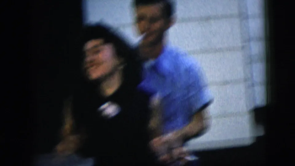 A man in a blue shirt and woman in a black dress move together in a lively 1958 New York City home-movie dance moment.