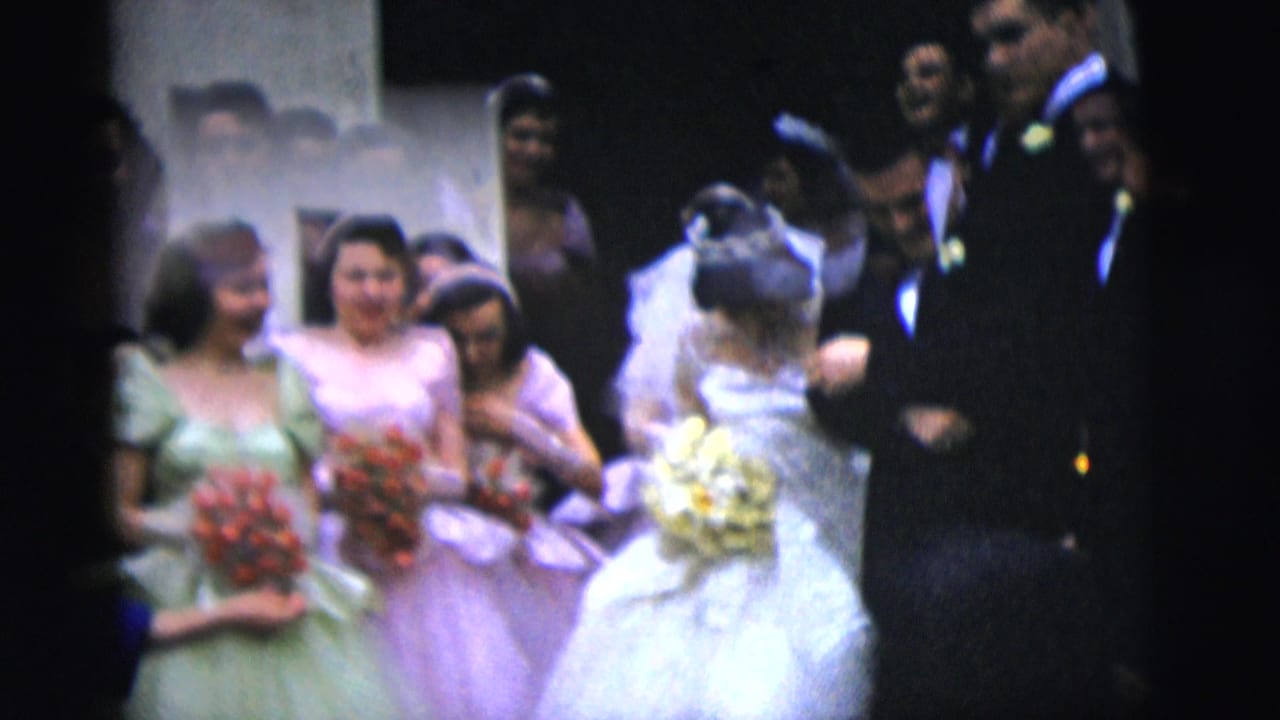 Bride turns near bridesmaids with bouquets while the groom stands beside her.