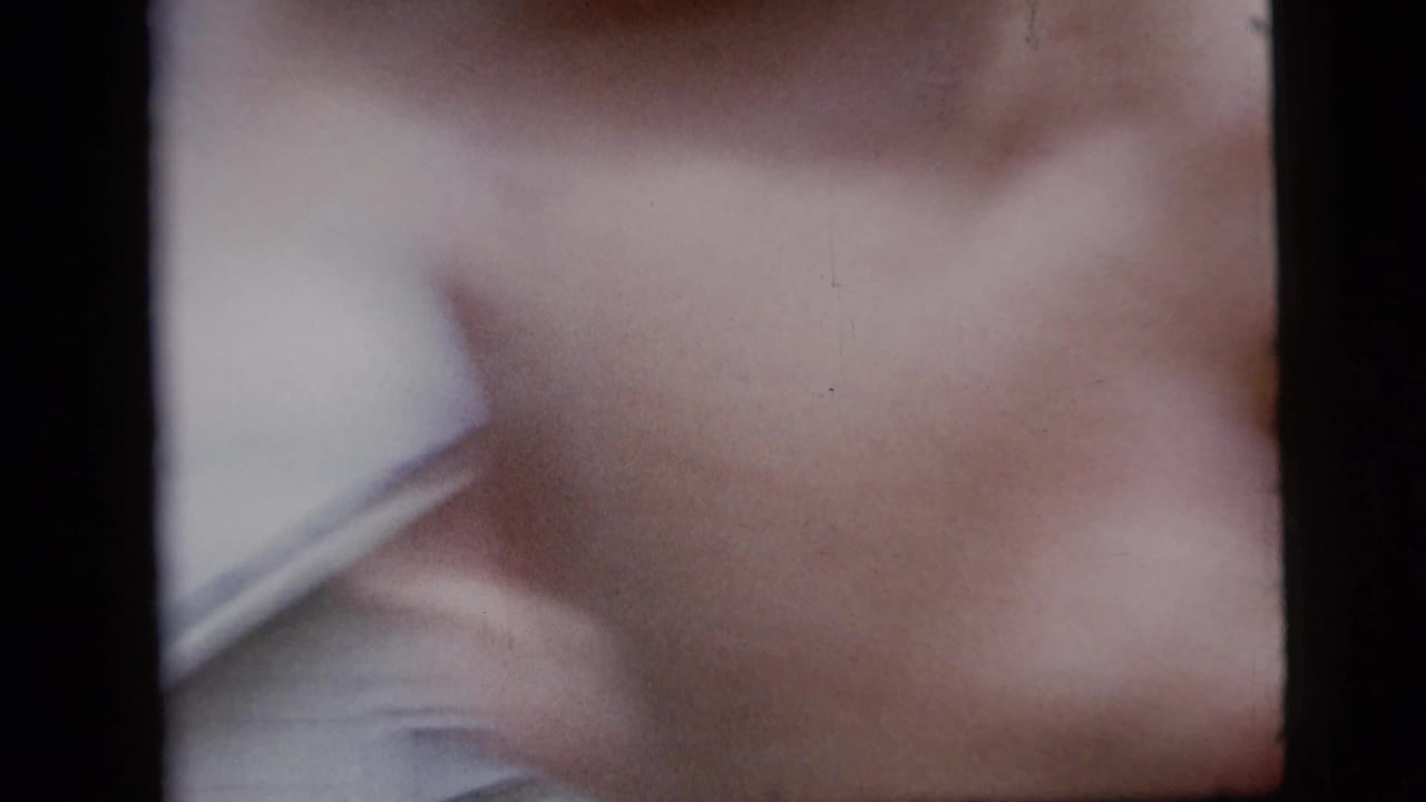 The 8mm frame becomes an abstract close-up of the man's white shirt and blue suit as he moves very close to the camera.