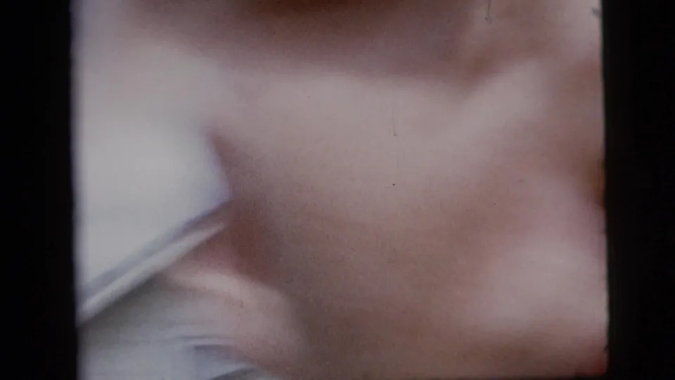 The 8mm frame becomes an abstract close-up of the man's white shirt and blue suit as he moves very close to the camera.