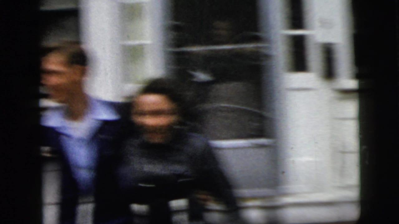 Blurred couple standing outside a white house doorway.