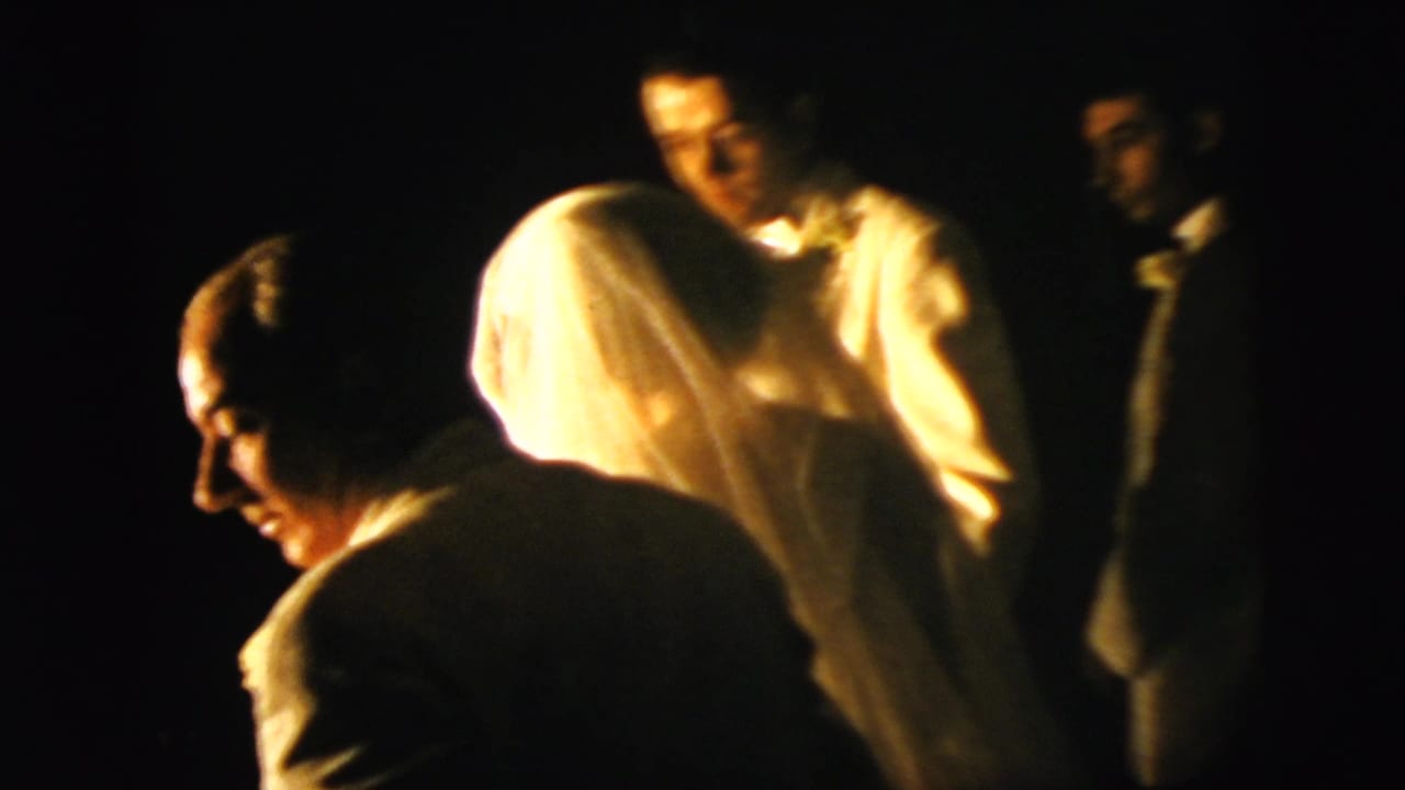 Dim 1958 New York City wedding frame with the veiled bride, groom, and guests in a church-like interior.