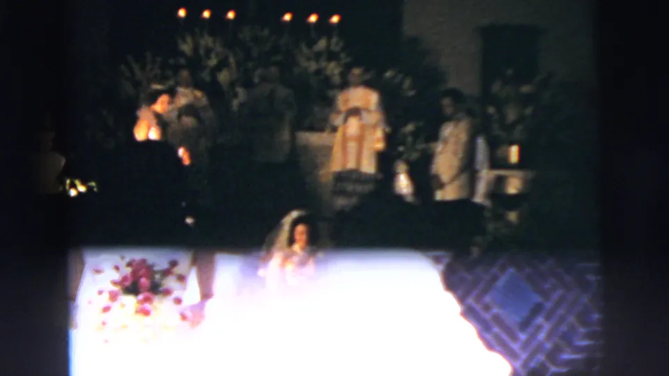 1958 New York City church wedding frame with the bride partly visible below a bright exposure flare and ceremony figures near the altar.