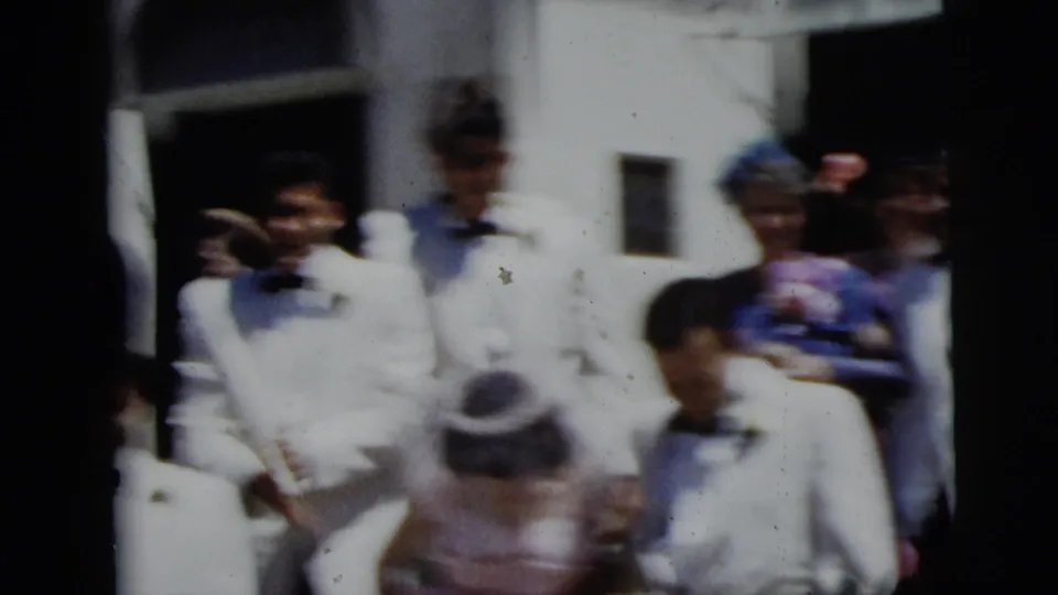 A soft, handheld 1958 New York City wedding frame shows guests and the bride amid a crowded rice-throwing exit.