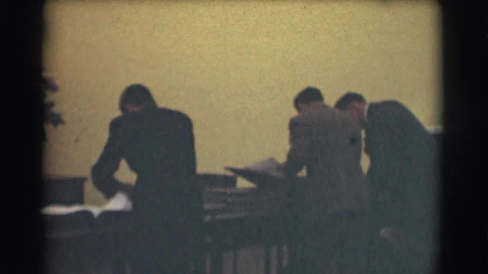 Several suited men in the Saint Louis interior appear to review large books or documents at desks.