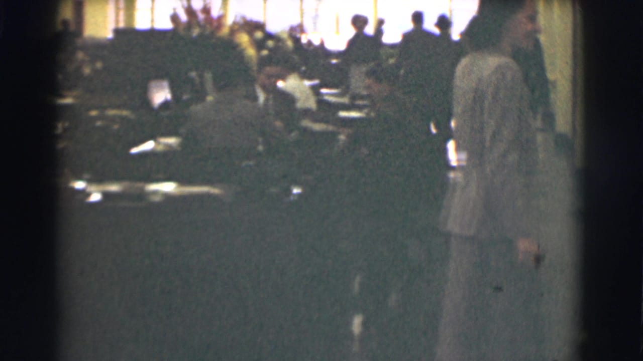 The final frame shows the woman at the right edge of the Saint Louis office interior, with workers and bright windows in the background.