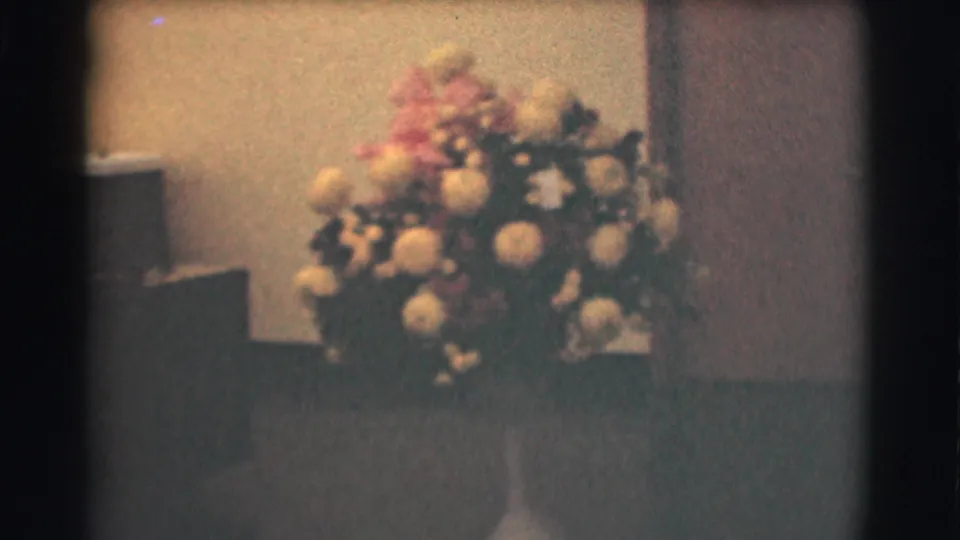 1959 Saint Louis frame focused on a large white and pink floral arrangement in a formal indoor space.