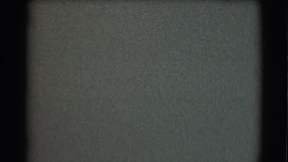 Low-light 8mm frame from the St. Louis clip, with minimal visible detail beyond grain and frame edges.