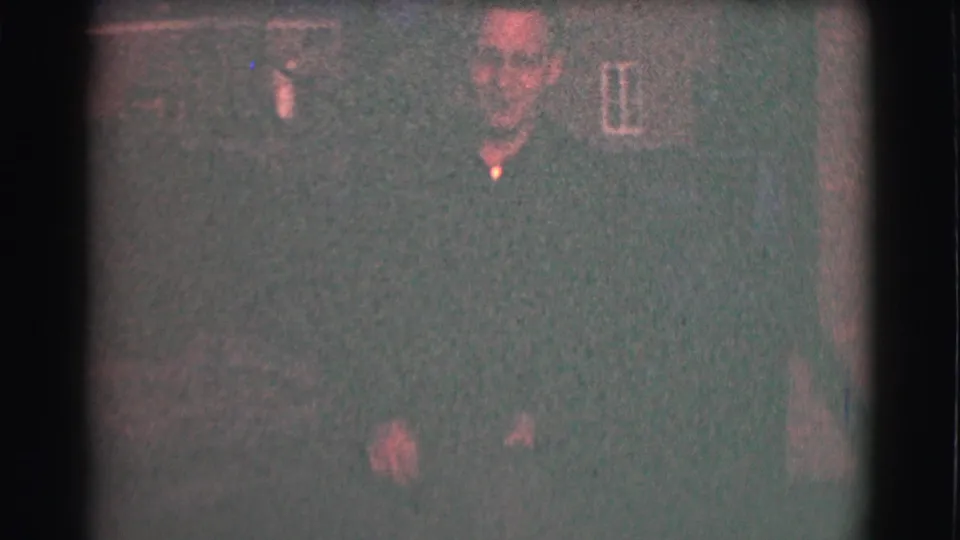 Adult man in glasses and a dark shirt appears outdoors at night in Saint Louis home-movie footage from 1959.