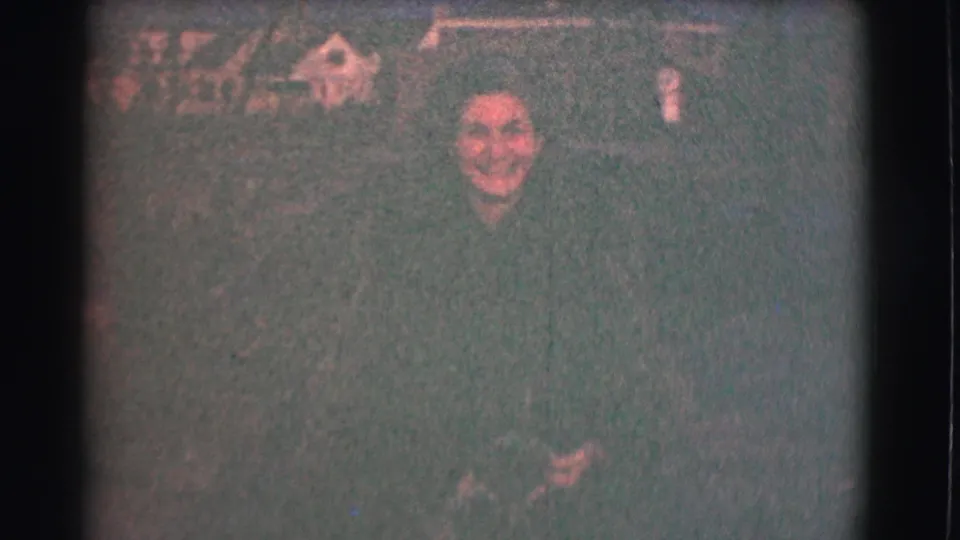 A smiling woman appears in a Saint Louis night scene from 1959, framed closely against a dark, grainy residential-looking background.
