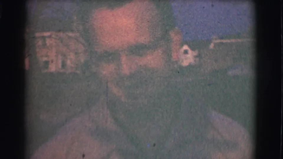 A close, grainy 8mm view shows the adult man’s face and shirt as he comes near the camera in the 1959 Saint Louis footage.