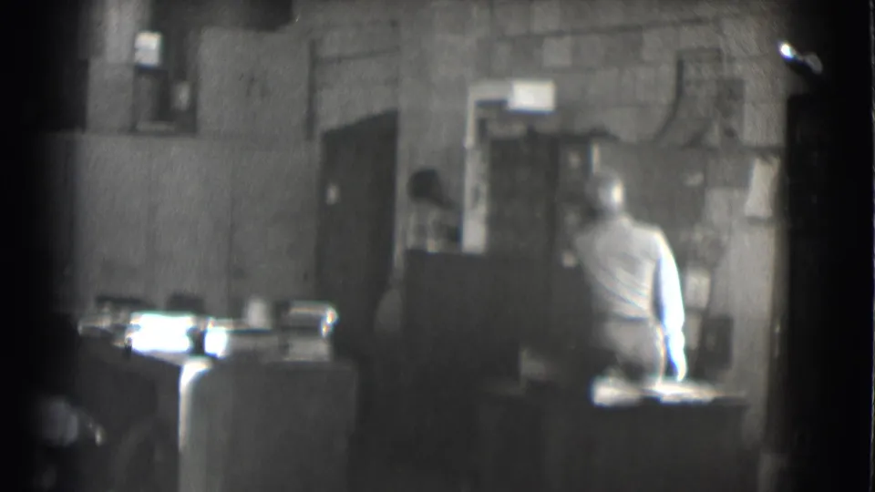 The final frame shows the seated man turned toward the office interior, with a second person partly visible in the background.