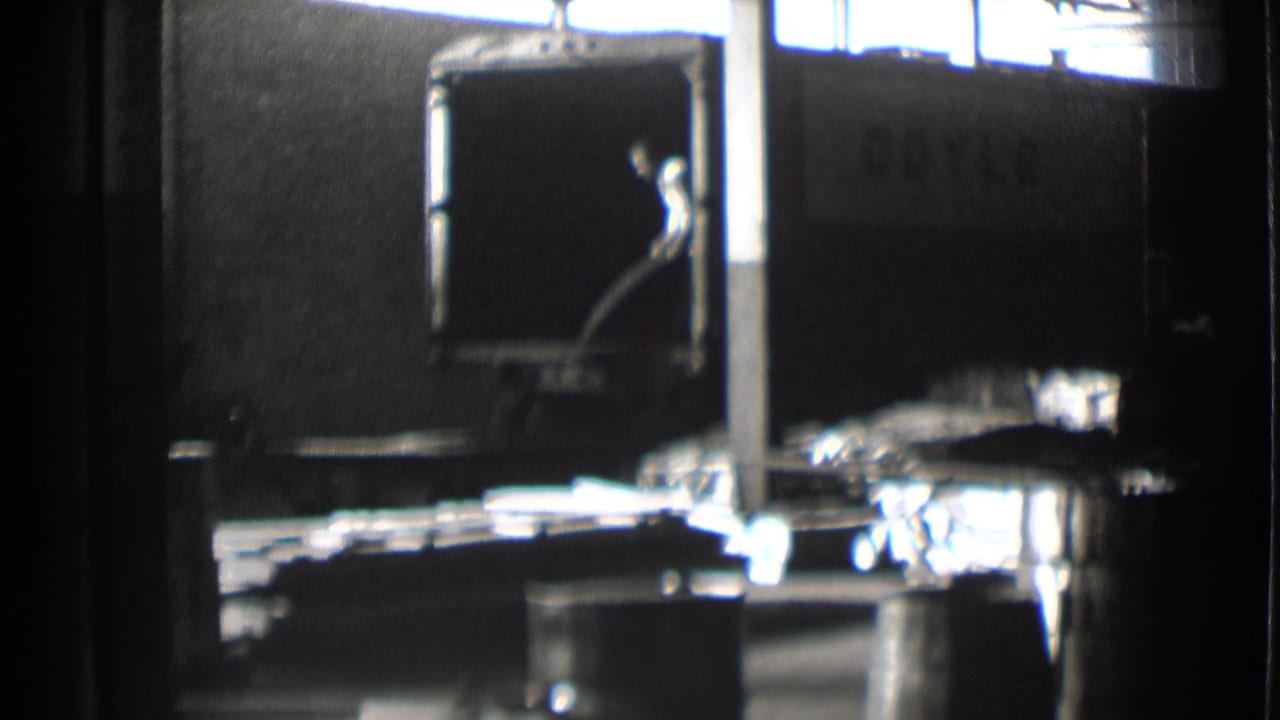 Metal sheets extend across a factory loading surface beside a dark truck panel.