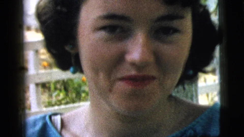 At the end of the 1961 Camden clip, the woman faces the camera with a closed-mouth expression and blue earrings visible.