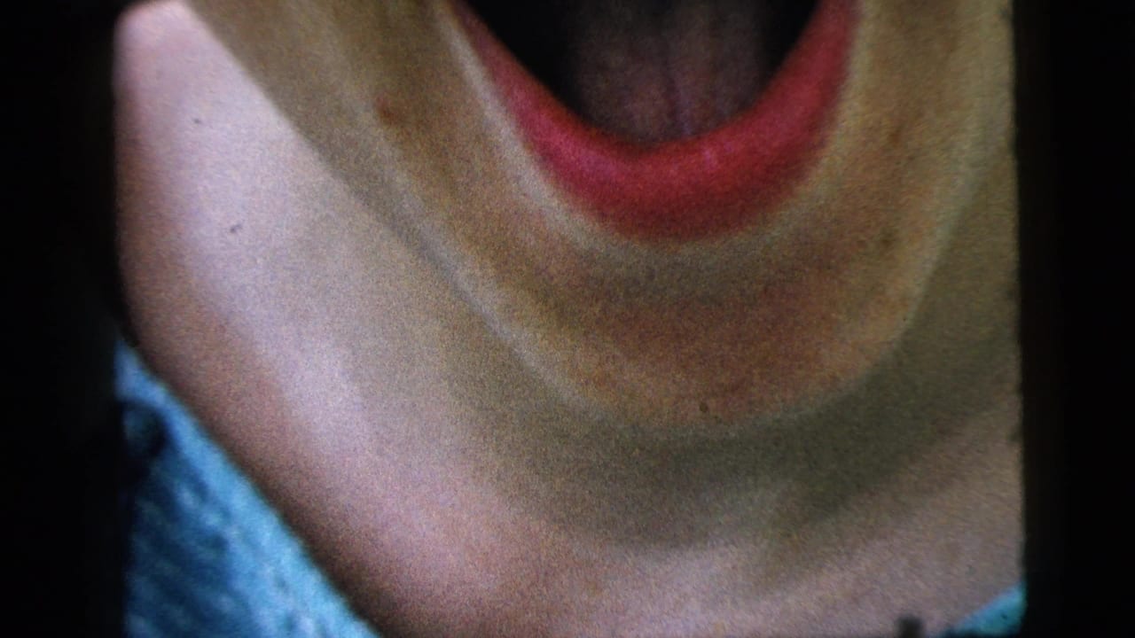 Extreme close-up of the woman's mouth and neck as she laughs.