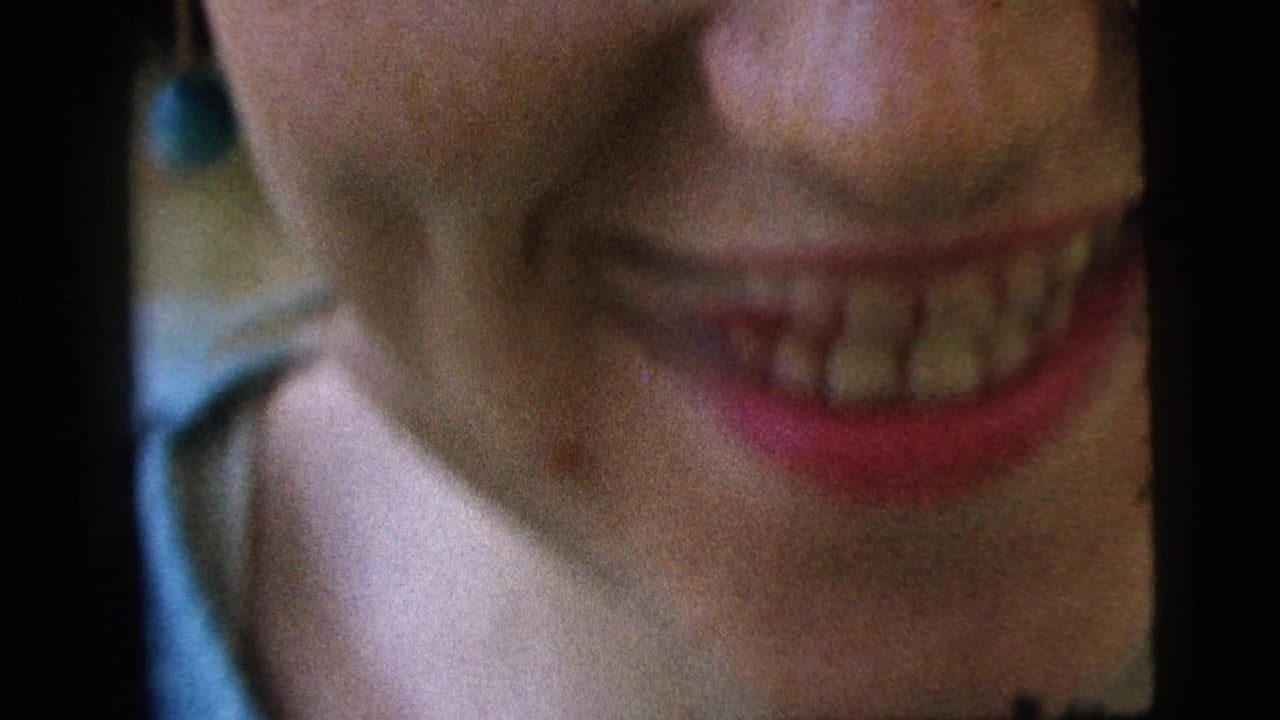 Camden 1961 8mm close-up of a young woman smiling near the camera, cropped across her lower face and chin.