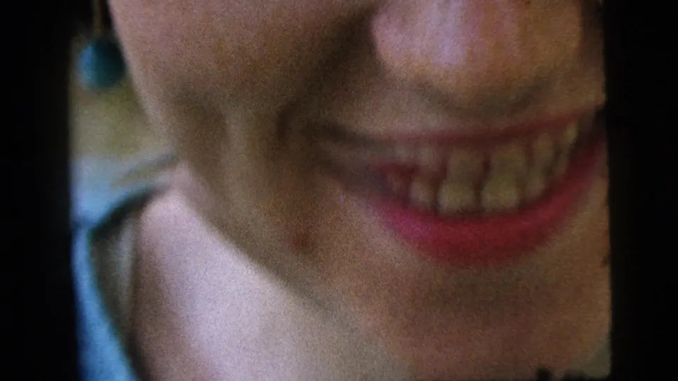 Camden 1961 8mm close-up of a young woman smiling near the camera, cropped across her lower face and chin.