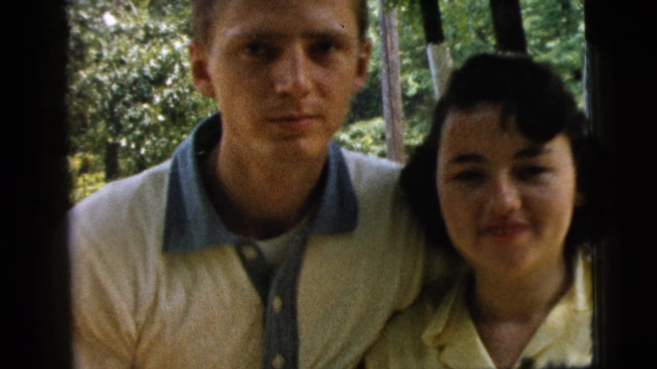 Closer view of the couple standing shoulder to shoulder outdoors.