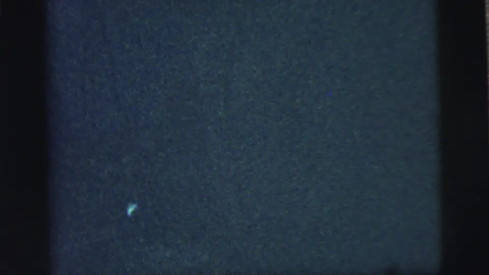 A mostly dark, underexposed 8mm frame from the Camden, New Jersey home movie, with no clear subjects visible.