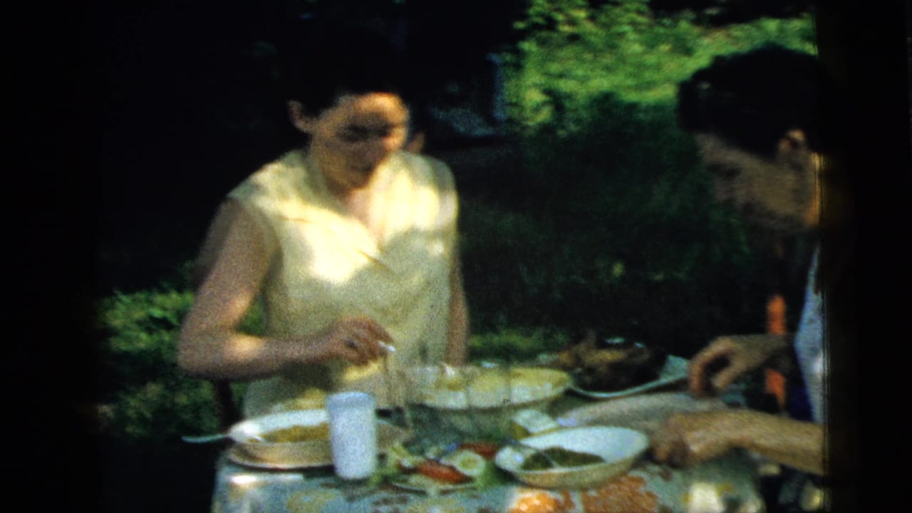 Two women seated at an outdoor lunch table with plates and glasses.