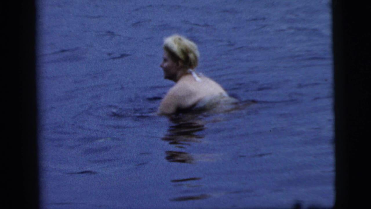 Woman in a bathing suit turns in calm water.