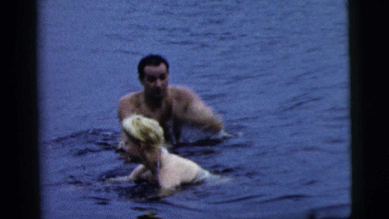 1961 Camden, New Jersey 8mm frame showing two adults close together in lake water during a casual swim.