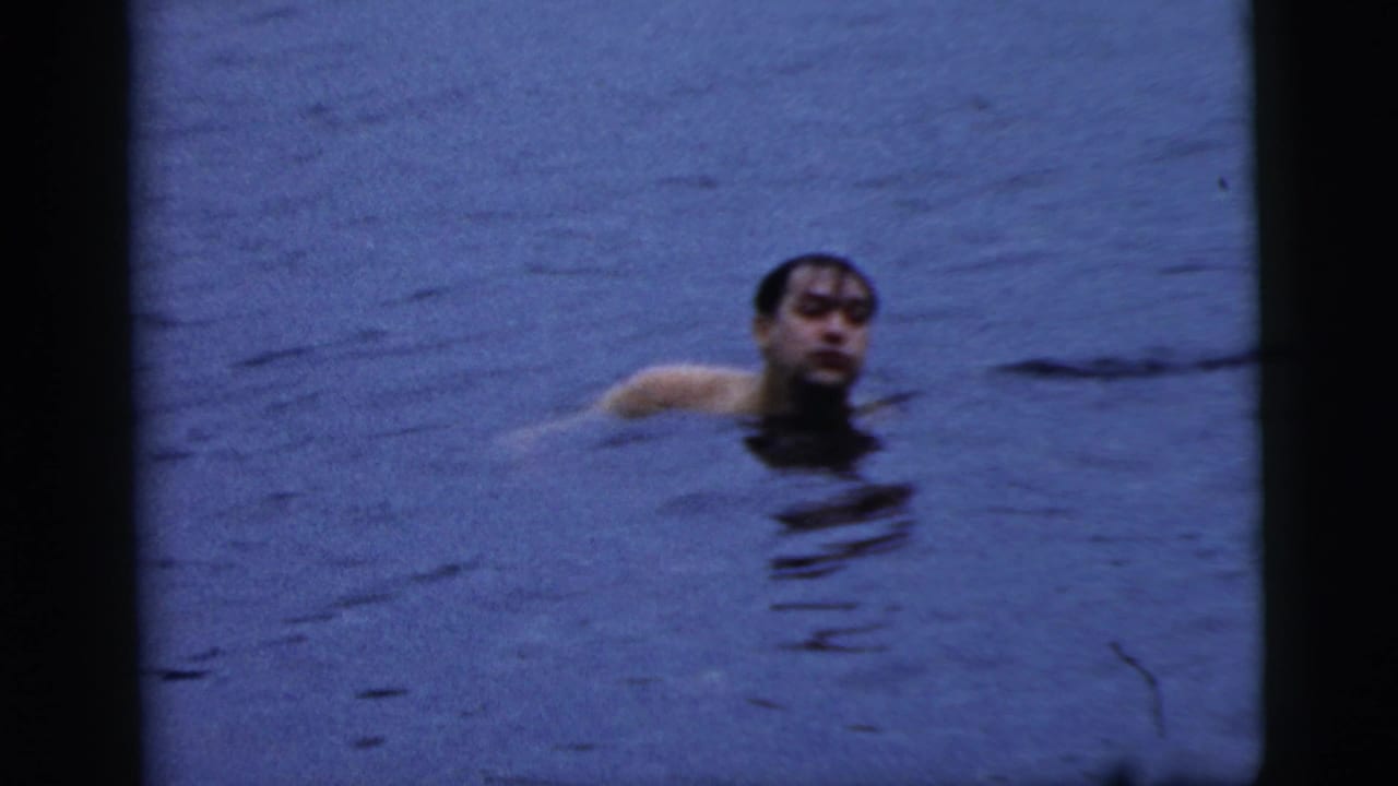 Swimmer's head and shoulders visible above blue lake water.