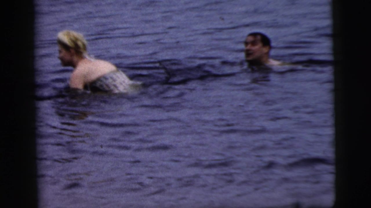 Woman in light swimwear and another swimmer are visible in open water.