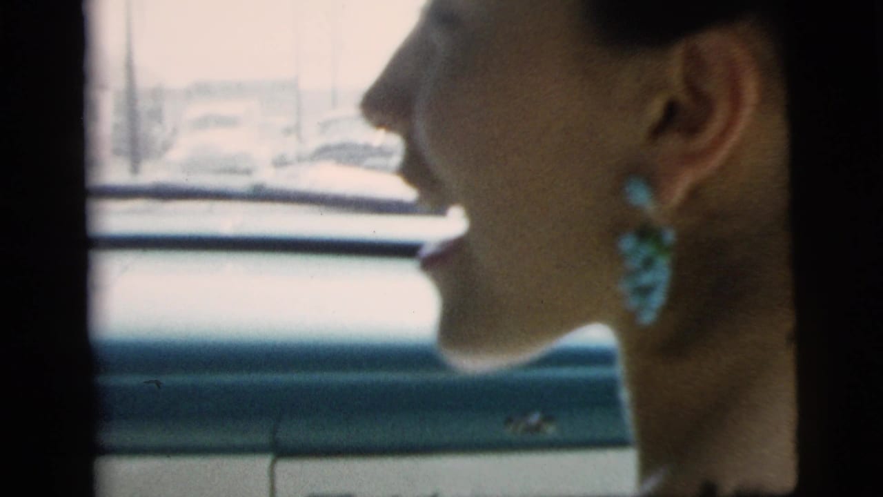 Young woman in profile wearing large turquoise earrings while riding in a car in Camden, New Jersey, 1961.
