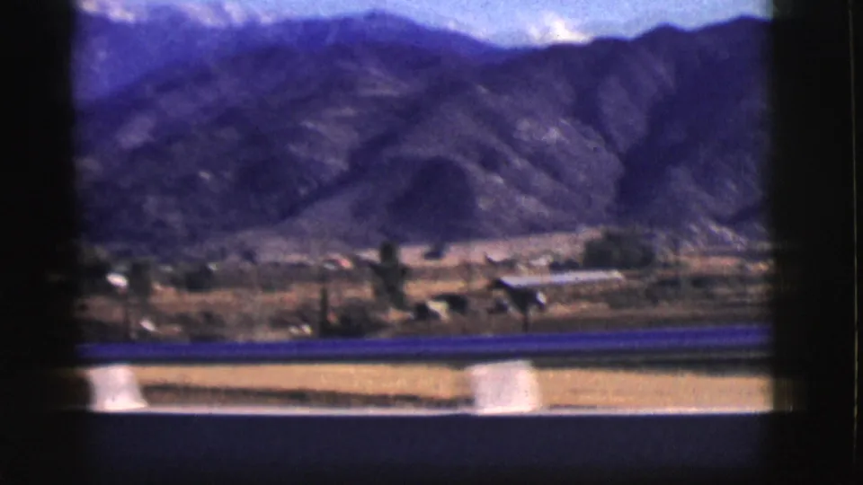 Clarkdale-area rural foreground and mountain slope seen from a moving vehicle in 1961 archival 8mm footage.
