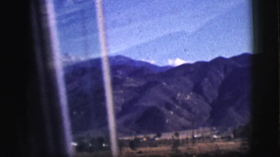 A moving-car view in Clarkdale, Arizona shows dark window edges, streaked glass, mountains, and a low rural valley.