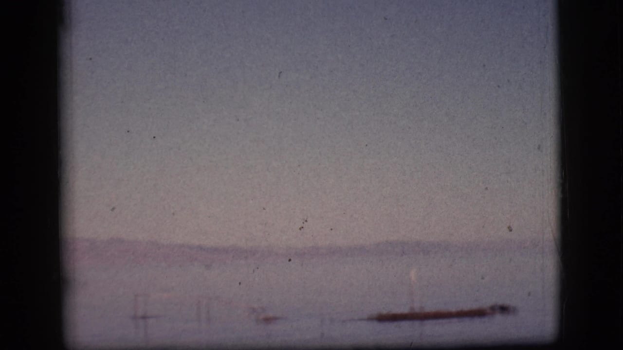 Broad hazy water view with a faint shoreline and dark film border.