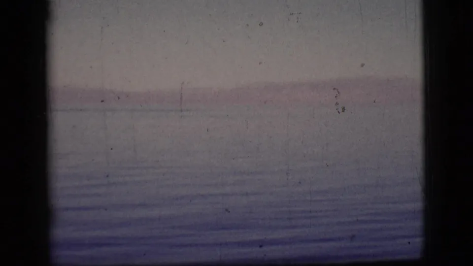 Soft 8mm view of calm lake or reservoir water near the supplied Arizona location, with a faint shore and subdued color fading.