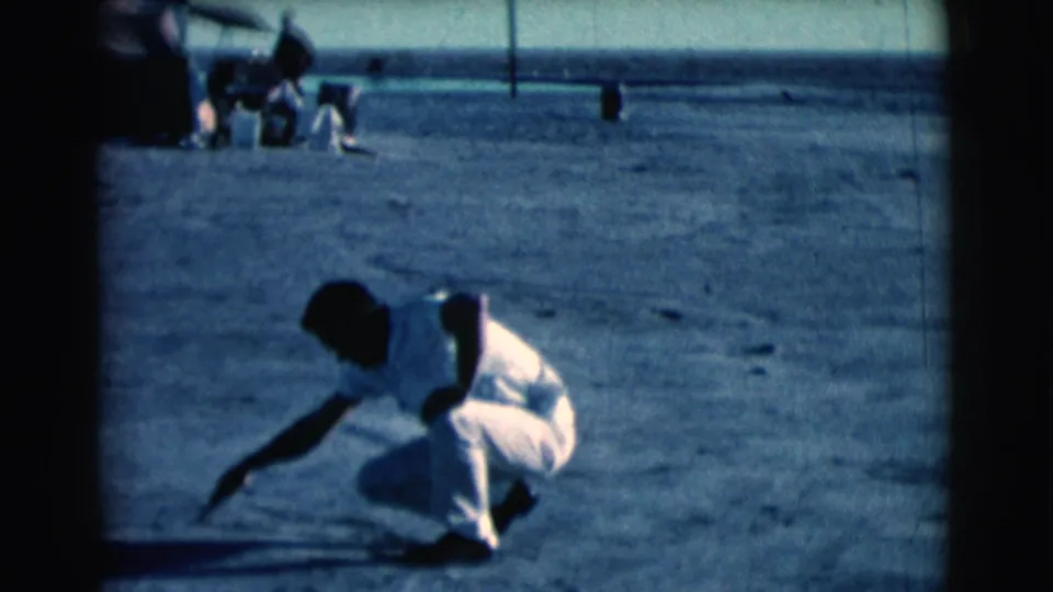 In the final frame, the man crouches in the dusty Clarkdale field and reaches toward the ground with a small tool or stick.