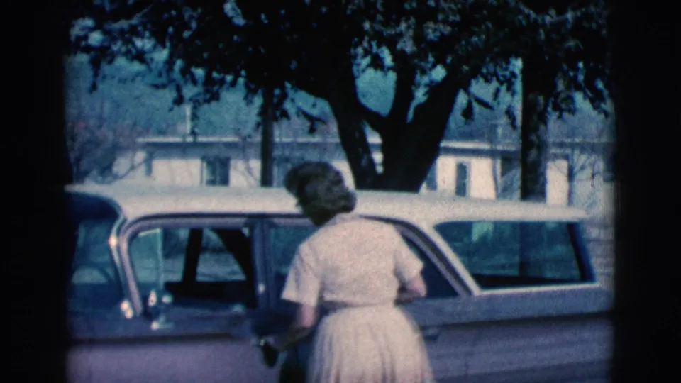 In the suburban Clarkdale view, the woman faces the station wagon door, framed by a large tree, house windows, and the parked car roofline.