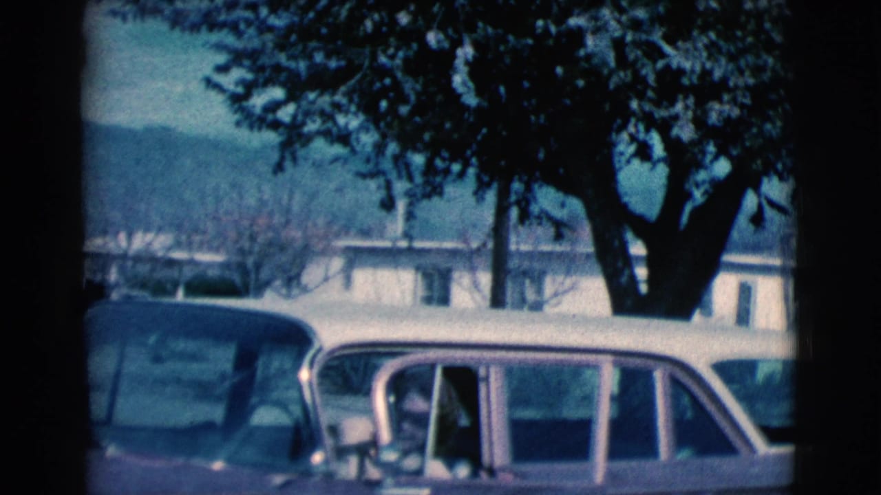 Woman is partly inside a vintage car with the door open.