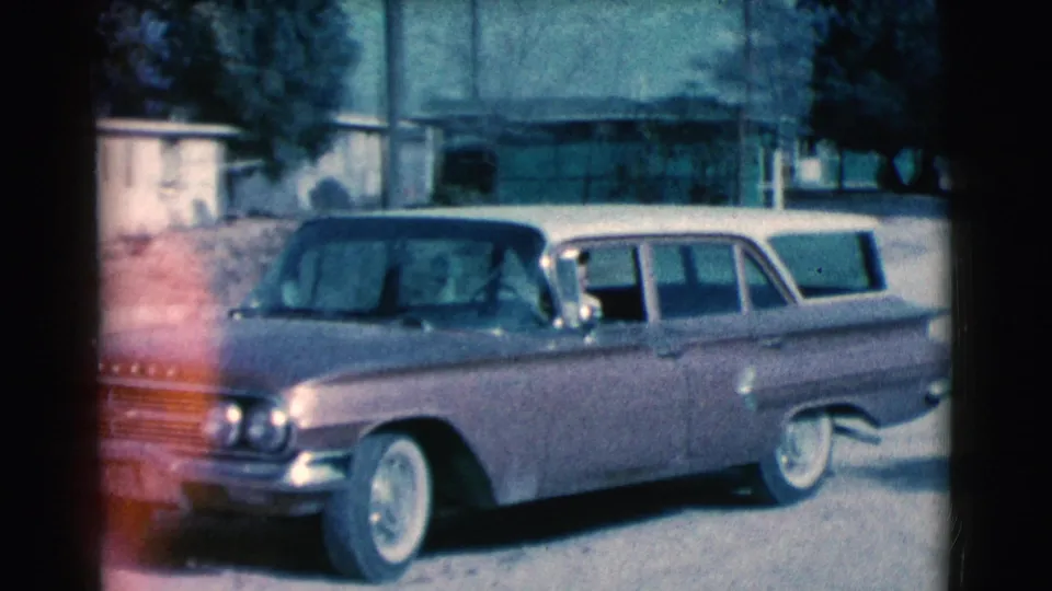 The station wagon appears farther along the street, angled toward the camera with trees and Clarkdale-area hills behind it.