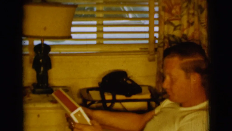 In the final frame, the young man remains seated in profile with the record album in a warm 1961 Clarkdale home interior.