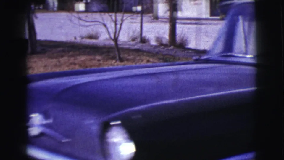 A close side view shows the dark car body and window area moving past the camera in the Clarkdale, Arizona, 1961 home-movie scene.