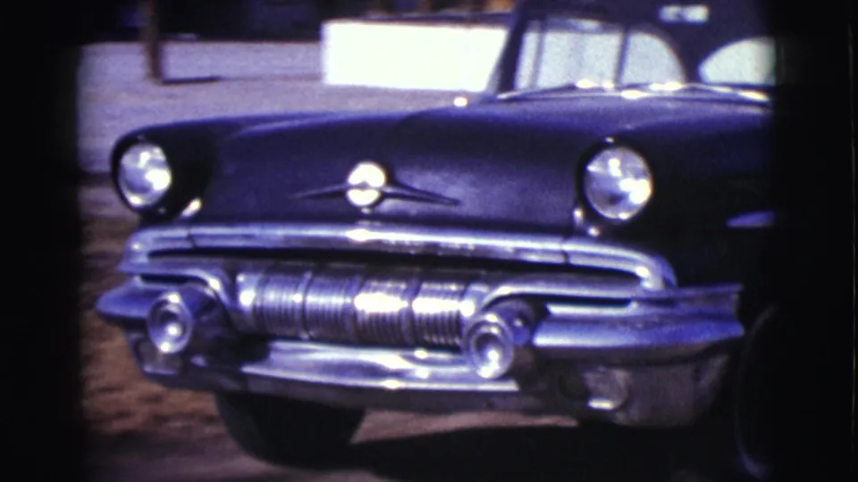 The front of the dark mid-century car is visible in Clarkdale, Arizona, 1961, showing chrome details, round headlights, and the windshield area.