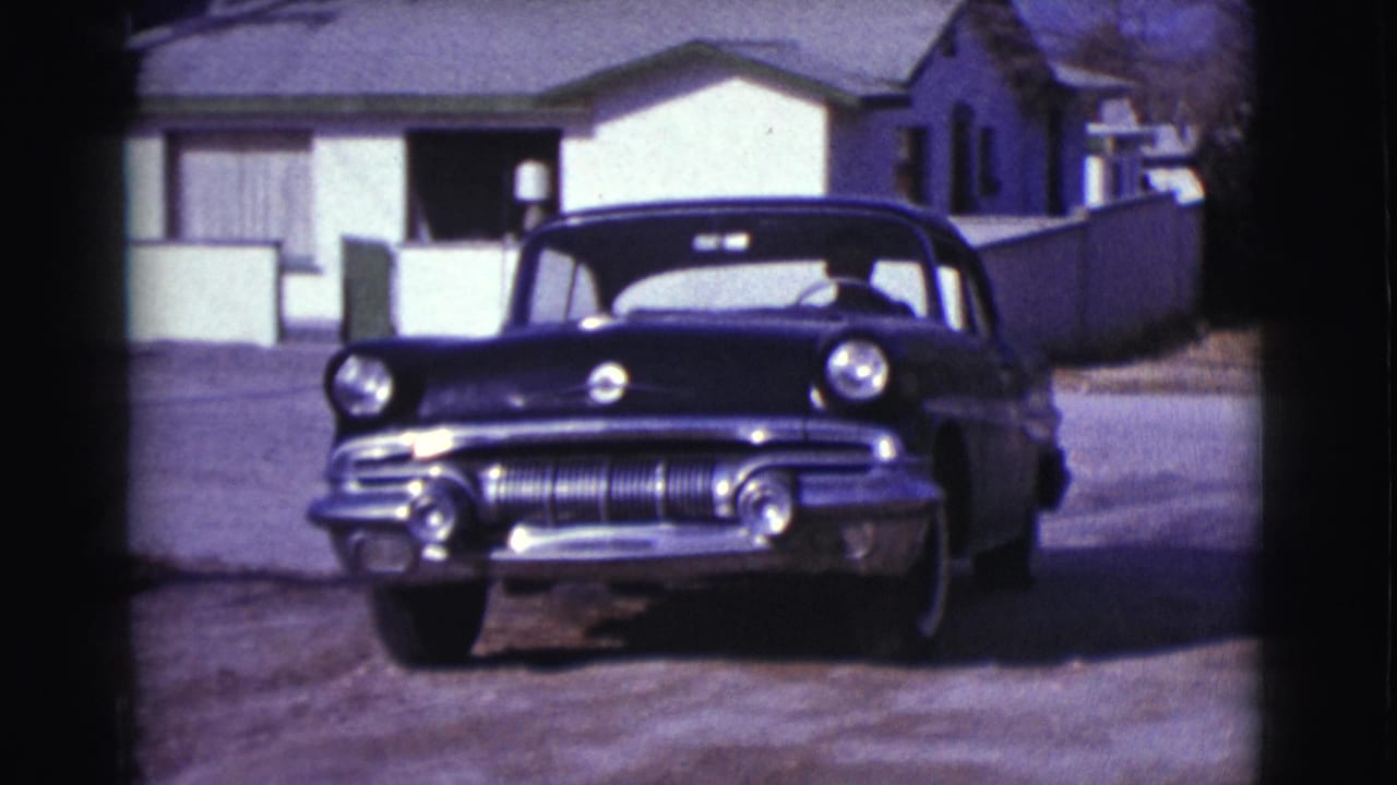 The car backs out from a Clarkdale driveway onto a quiet residential street, with low houses and fencing behind it.