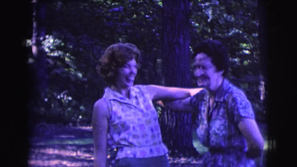 Two adult women smile and laugh near trees in Clarkdale, Arizona, in 1961 8mm home-movie footage.