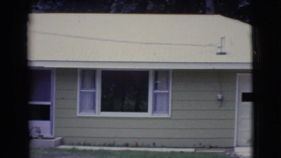 1961 Clarkdale, Arizona frame showing a green house facade with a large window, pale roof, utility meter, and white garage edge.