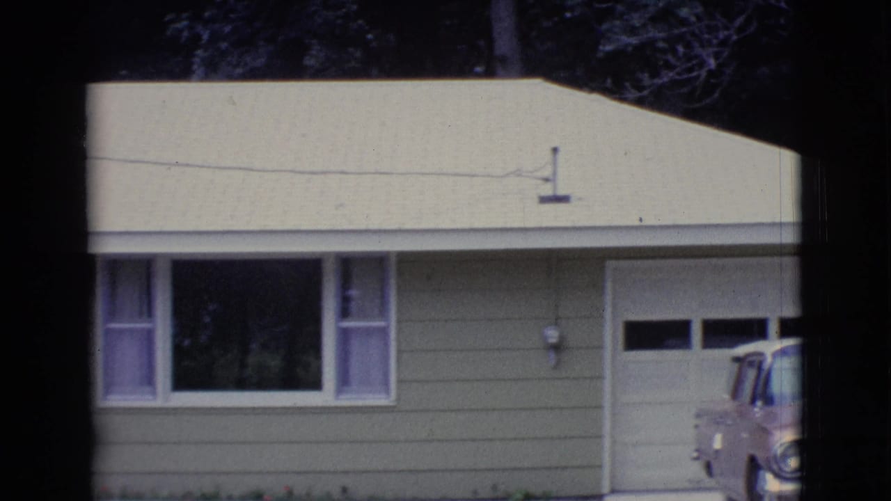 Single-story house with garage, front window, and part of a parked car at the driveway edge.