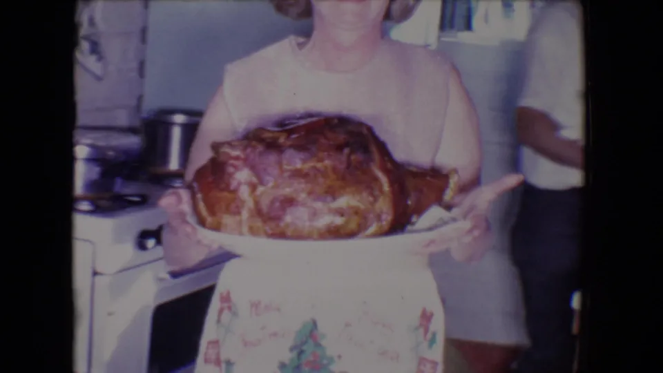 The final frame shows the woman holding the roasted turkey toward the camera in the 1961 Salton Sea kitchen interior.
