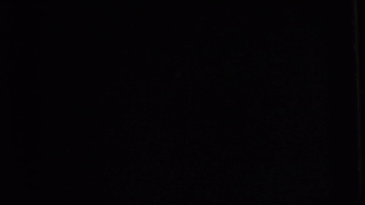 An underexposed 8mm frame with only faint borders visible before the outdoor action appears.