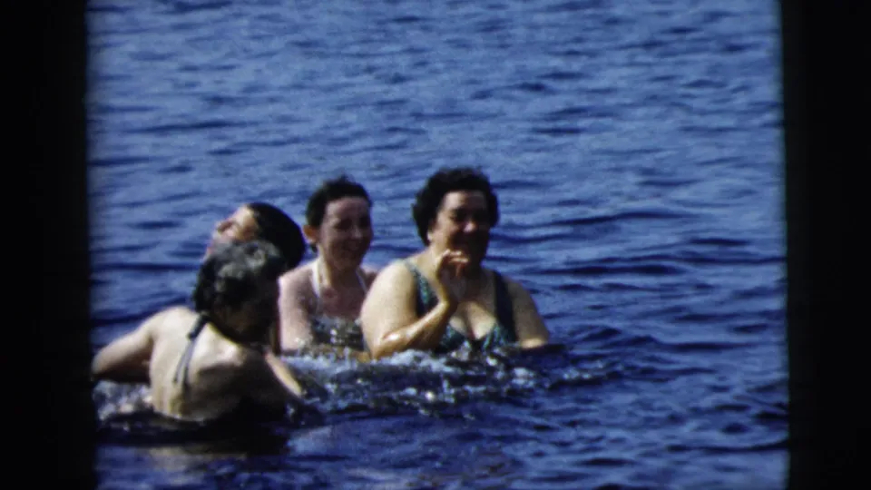 1962 Camden, New Jersey 8mm frame with four swimmers grouped in open water, including two women visible from the front and others turned partly away.